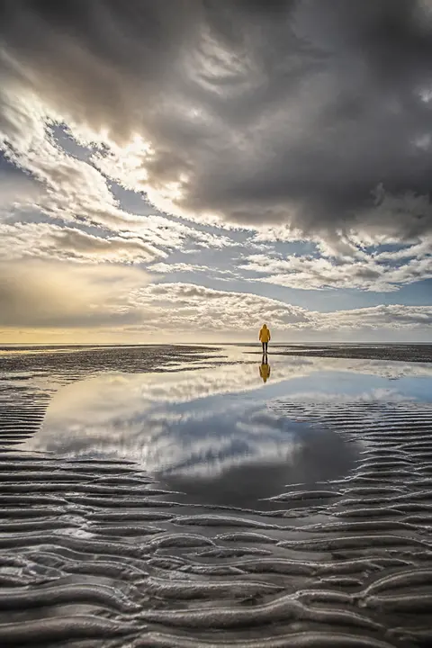 Reflective Tidal Flats Under Storm Clouds