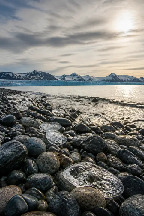 Smooth Pebble Beach Beneath Arctic Peaks